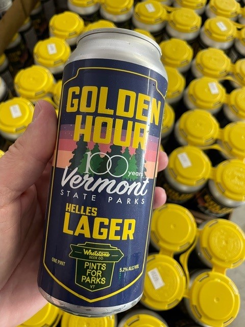 A hand holds the limited edition Whetstone Beer Co.'s Golden Hour Helles Lager Can.