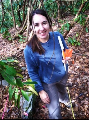 Katharine smiles while collecting data in a forest.