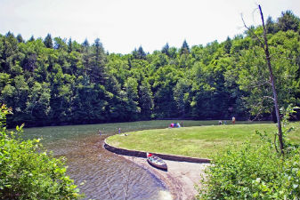 A lone canoe sitting on the tranquil beach at Little River State Park on a lovely summer day.