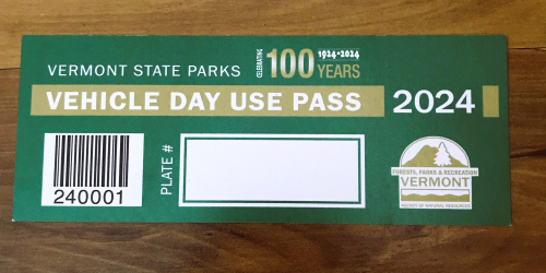 A green and gold vehicle pass with the Vermont State Parks 100th logo for 2024.