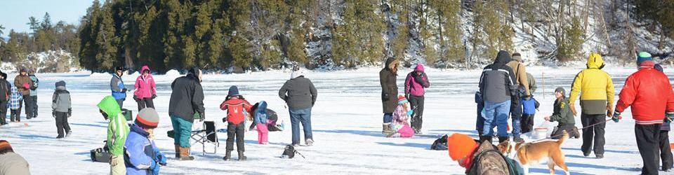 Group of families out on a frozen lake.